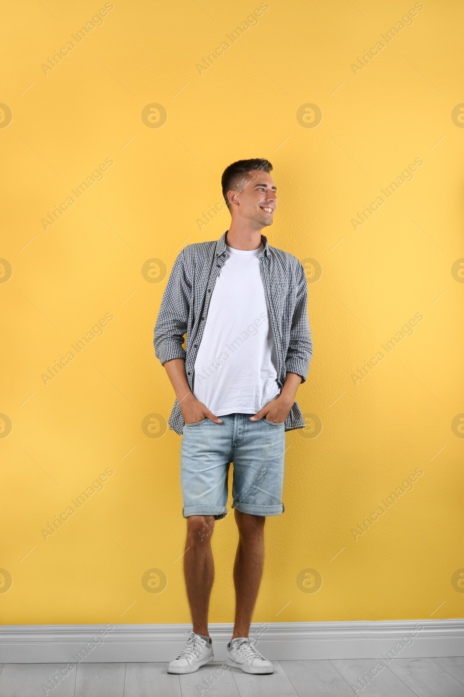 Photo of Handsome young man smiling on color background