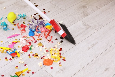 Photo of Sweeping trash after party with bristle broom indoors