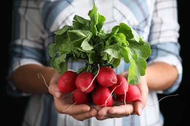 Photo of Farmer holding fresh ripe radish, closeup view