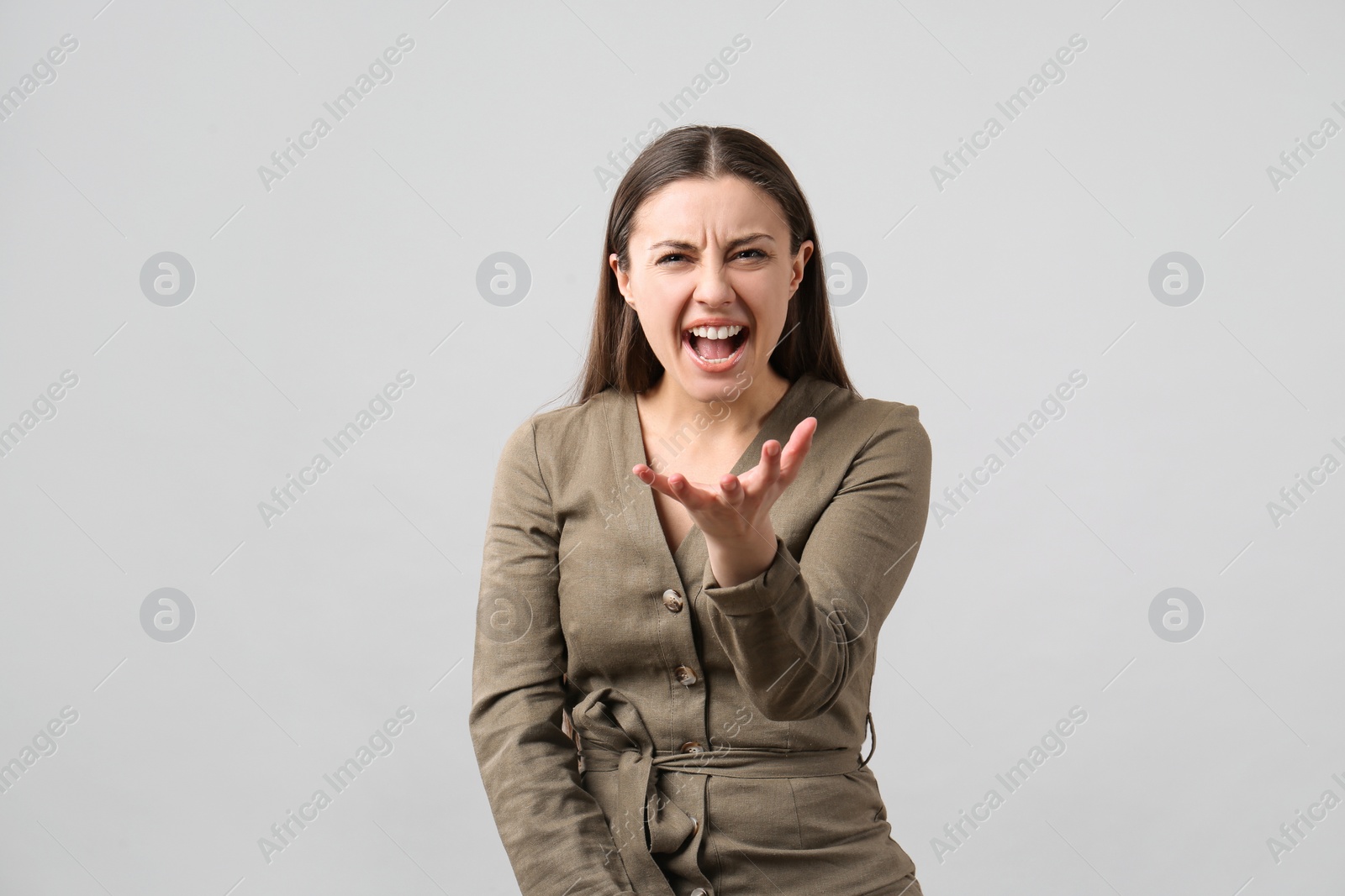 Photo of Portrait of emotional young woman on light grey background. Personality concept