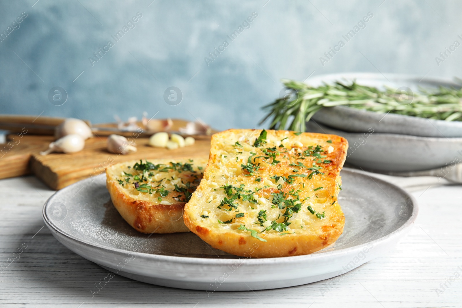 Photo of Plate with delicious homemade garlic bread on table