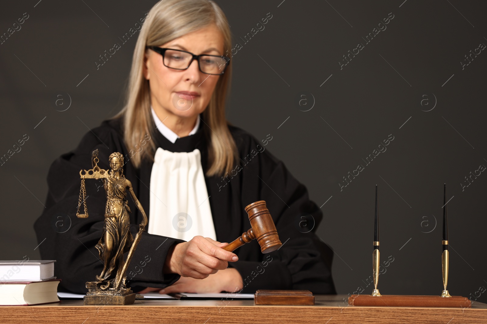 Photo of Judge striking mallet at wooden table indoors. Space for text