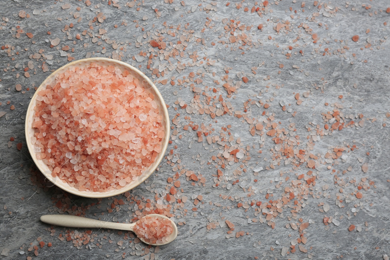 Photo of Pink himalayan salt on grey table, flat lay