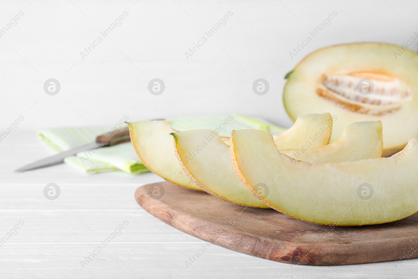 Photo of Pieces of delicious honeydew melon on white wooden table