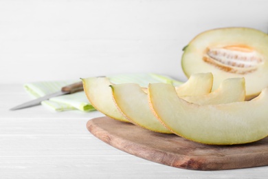 Photo of Pieces of delicious honeydew melon on white wooden table