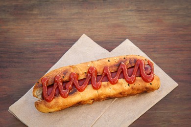 Photo of Fresh tasty hot dog with ketchup on wooden table