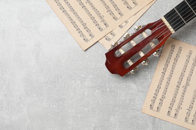 Photo of Composition with guitar and music notations on light table, flat lay. Space for text
