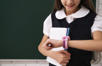 Girl with stylish smart watch in classroom, closeup