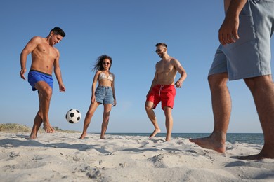 Photo of Group of friends playing football on beach