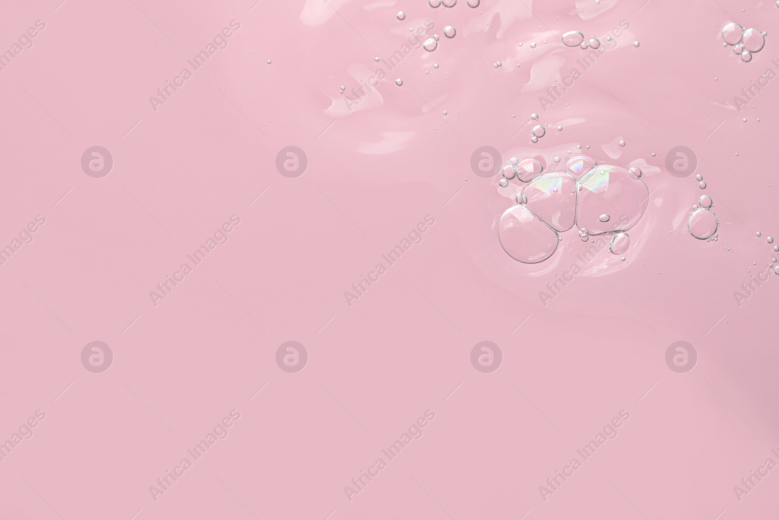 Photo of Transparent cleansing gel on pink background, top view with space for text. Cosmetic product