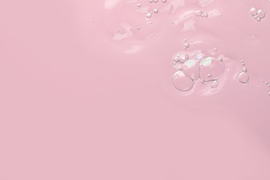 Photo of Transparent cleansing gel on pink background, top view with space for text. Cosmetic product