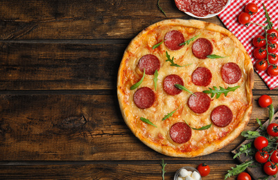 Photo of Flat lay composition with tasty pepperoni pizza on wooden table. Space for text