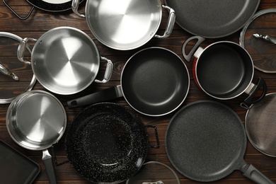 Photo of Set of modern cooking utensils on brown wooden table, flat lay