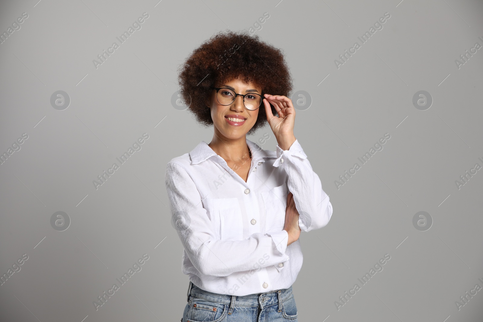Photo of Beautiful young woman in eyeglasses on grey background