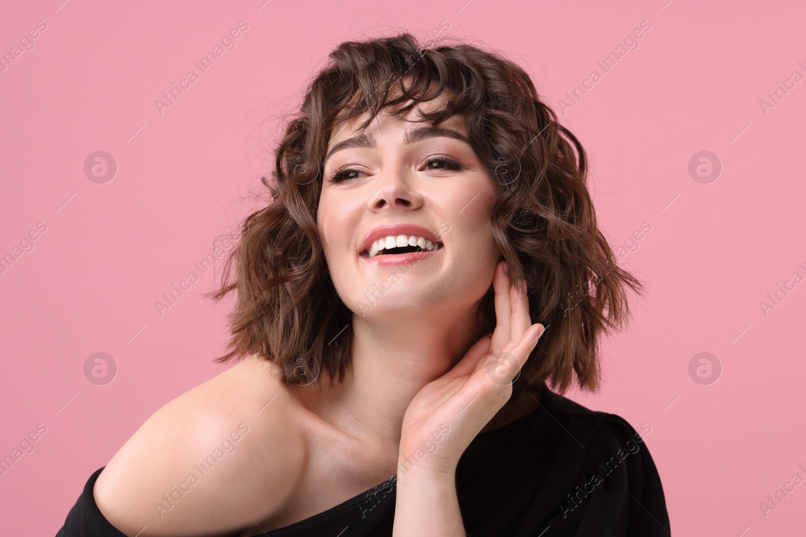 Photo of Portrait of beautiful young woman with wavy hairstyle on pink background