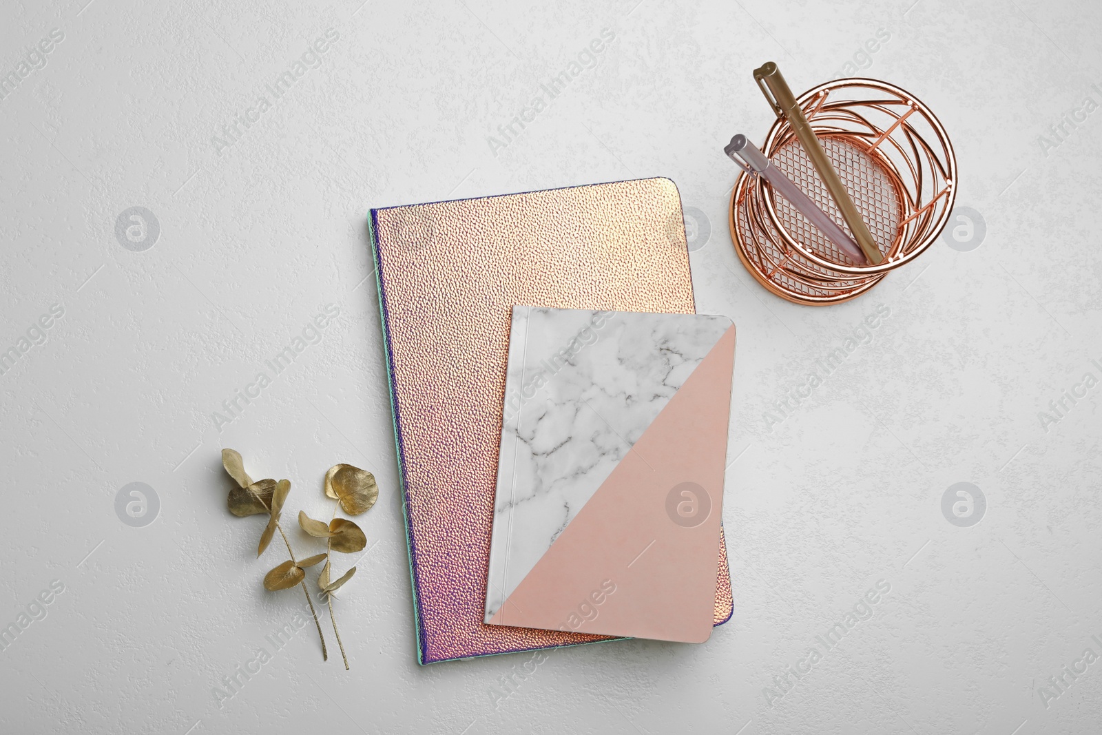 Photo of Stylish notebooks and decor elements on white table, flat lay