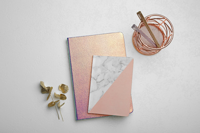 Photo of Stylish notebooks and decor elements on white table, flat lay