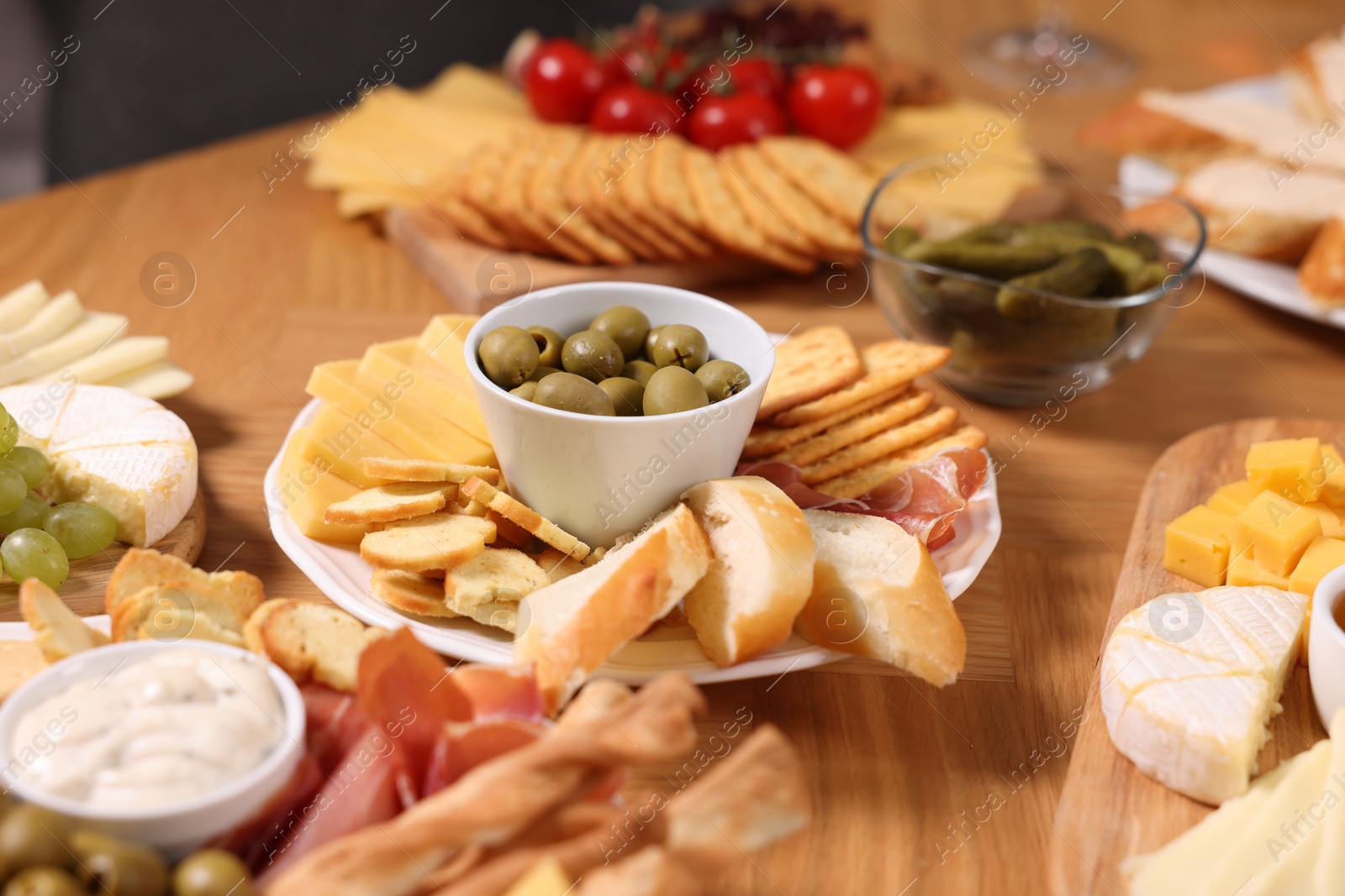 Photo of Assorted appetizers served on wooden table, closeup