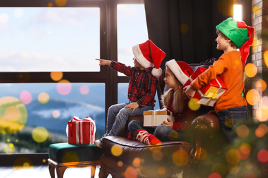 Little children waiting for Santa Claus near window indoors. Christmas holiday