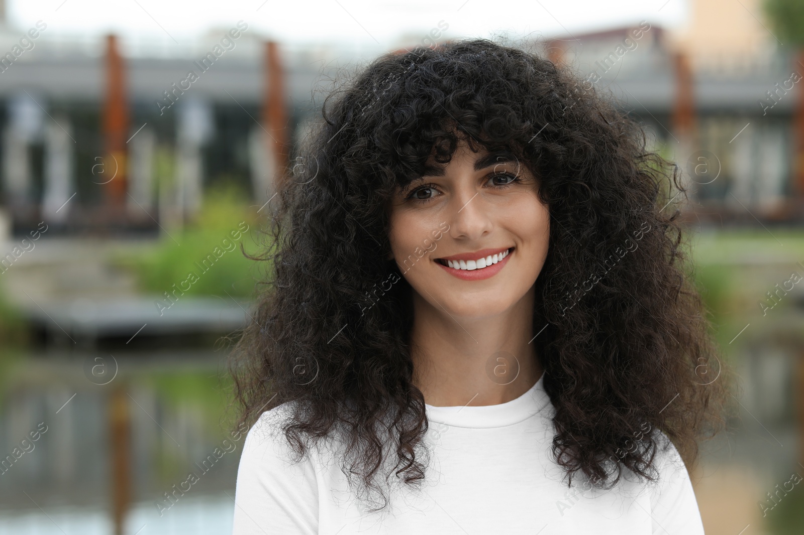 Photo of Portrait of beautiful woman posing outdoors. Attractive lady smiling and looking into camera. Space for text