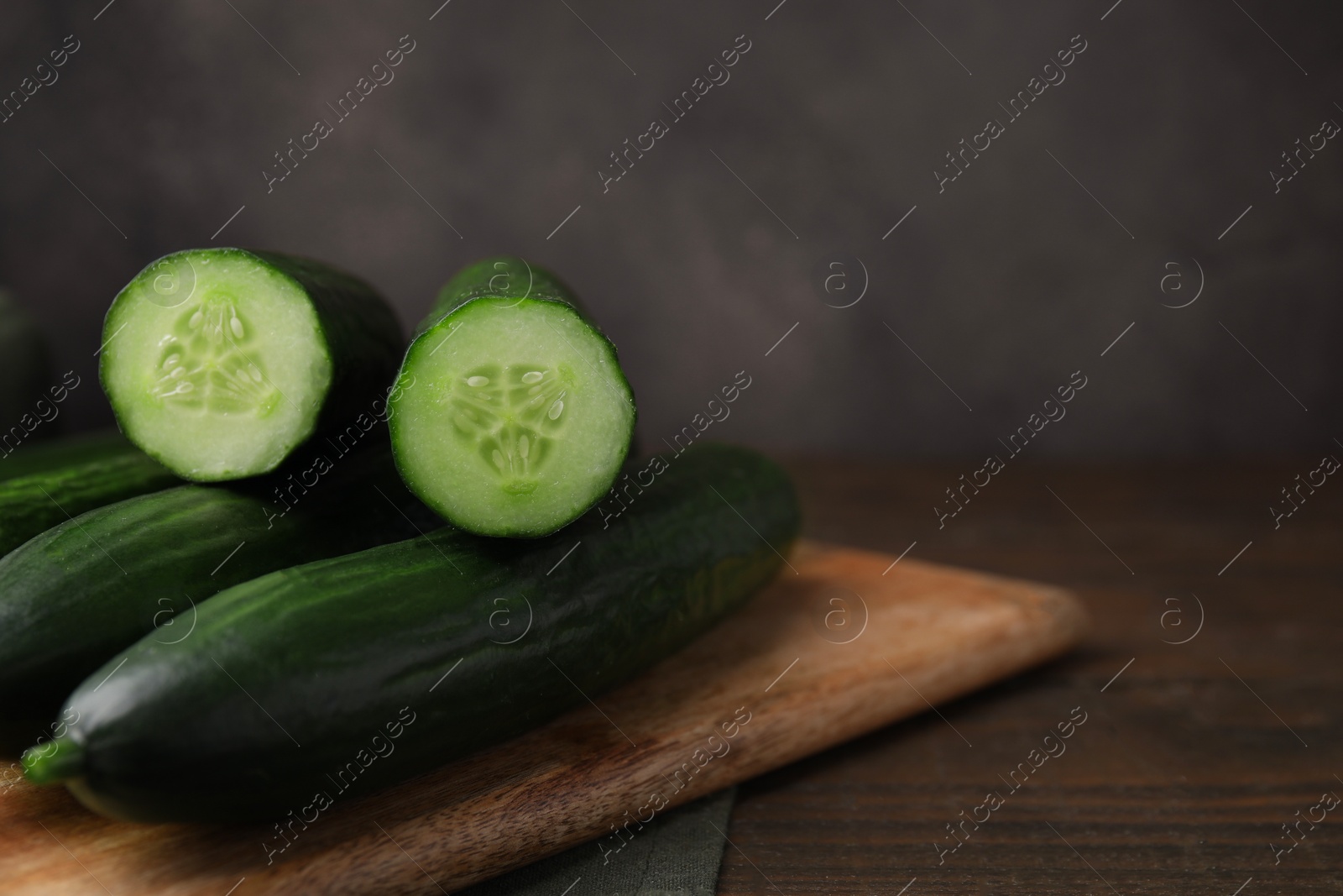 Photo of Fresh cucumbers on wooden table, closeup. Space for text