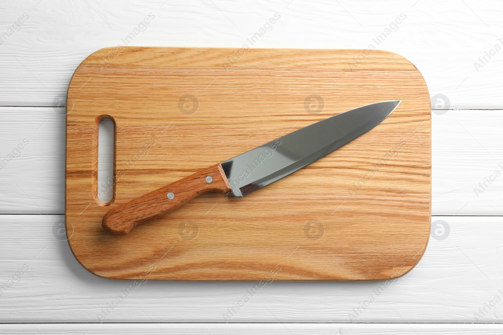 Photo of One sharp knife and board on white wooden table, top view