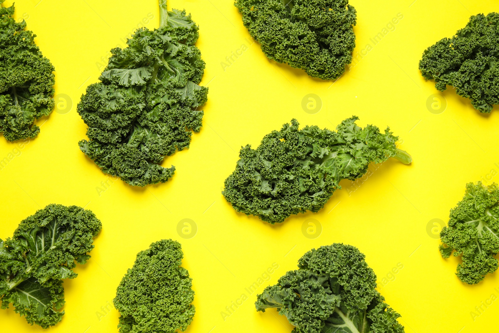 Photo of Fresh kale leaves on yellow background, flat lay