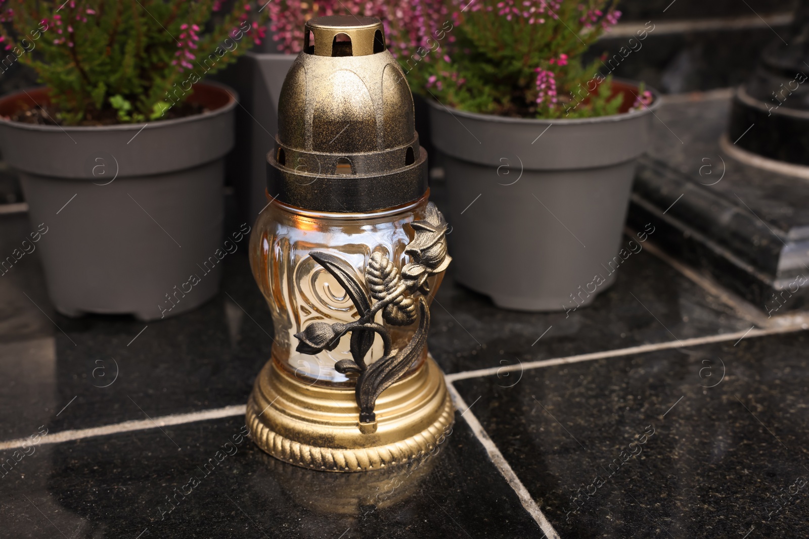 Photo of Grave lantern on black tiled surface at cemetery