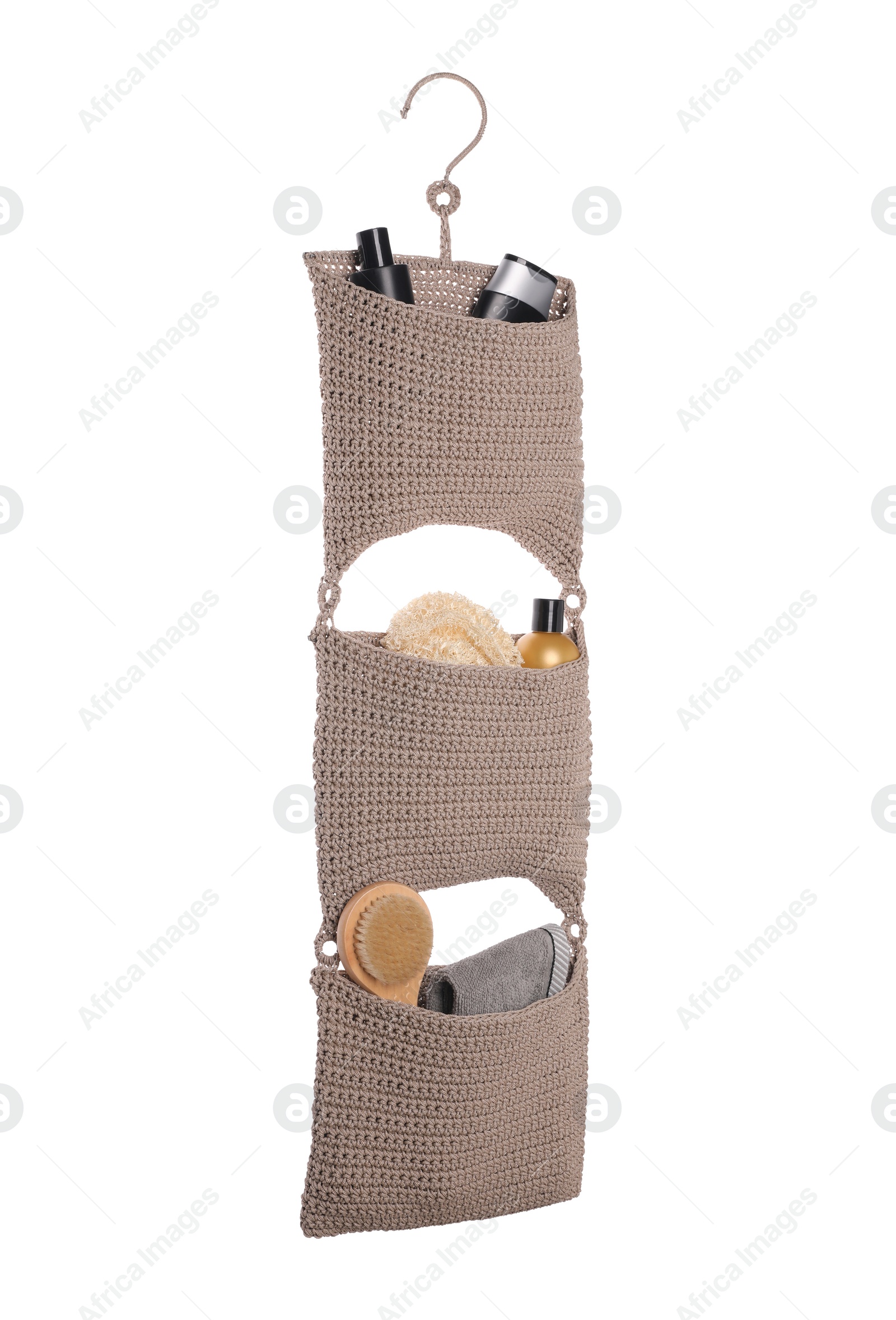 Photo of Stylish knitted organizer with toiletries and brush on white background. Bath accessory