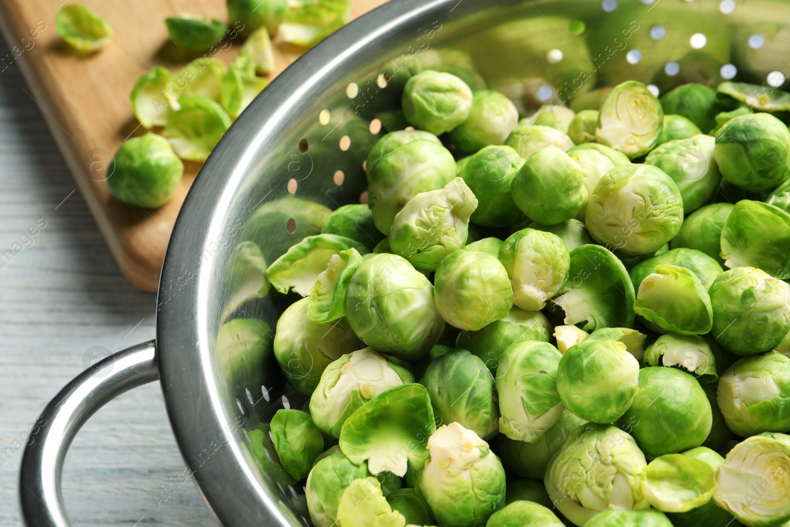 Photo of Tasty Brussels sprouts in colander on table, closeup