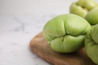 Photo of Fresh green chayote on light table, closeup. Space for text