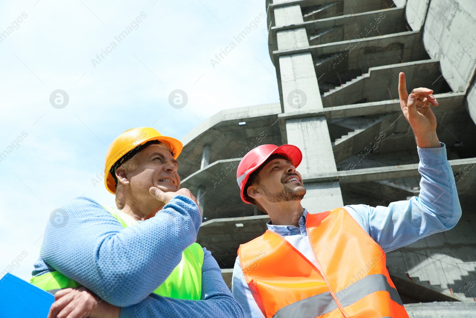 Photo of Professional engineers in safety equipment at construction site