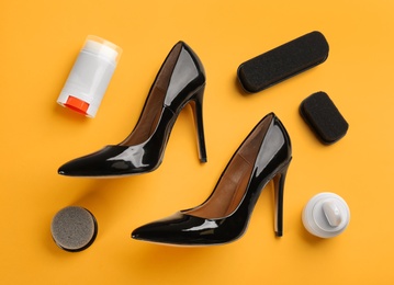 Photo of Flat lay composition with shoe care accessories and footwear on yellow background