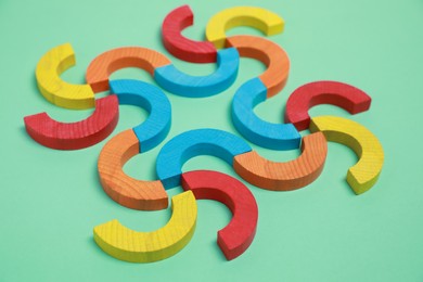 Photo of Colorful wooden pieces of play set on green background. Educational toy for motor skills development