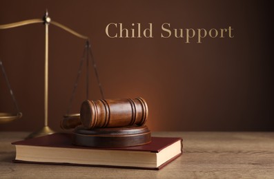 Judge's gavel, scales of justice and book on wooden table. Child support concept