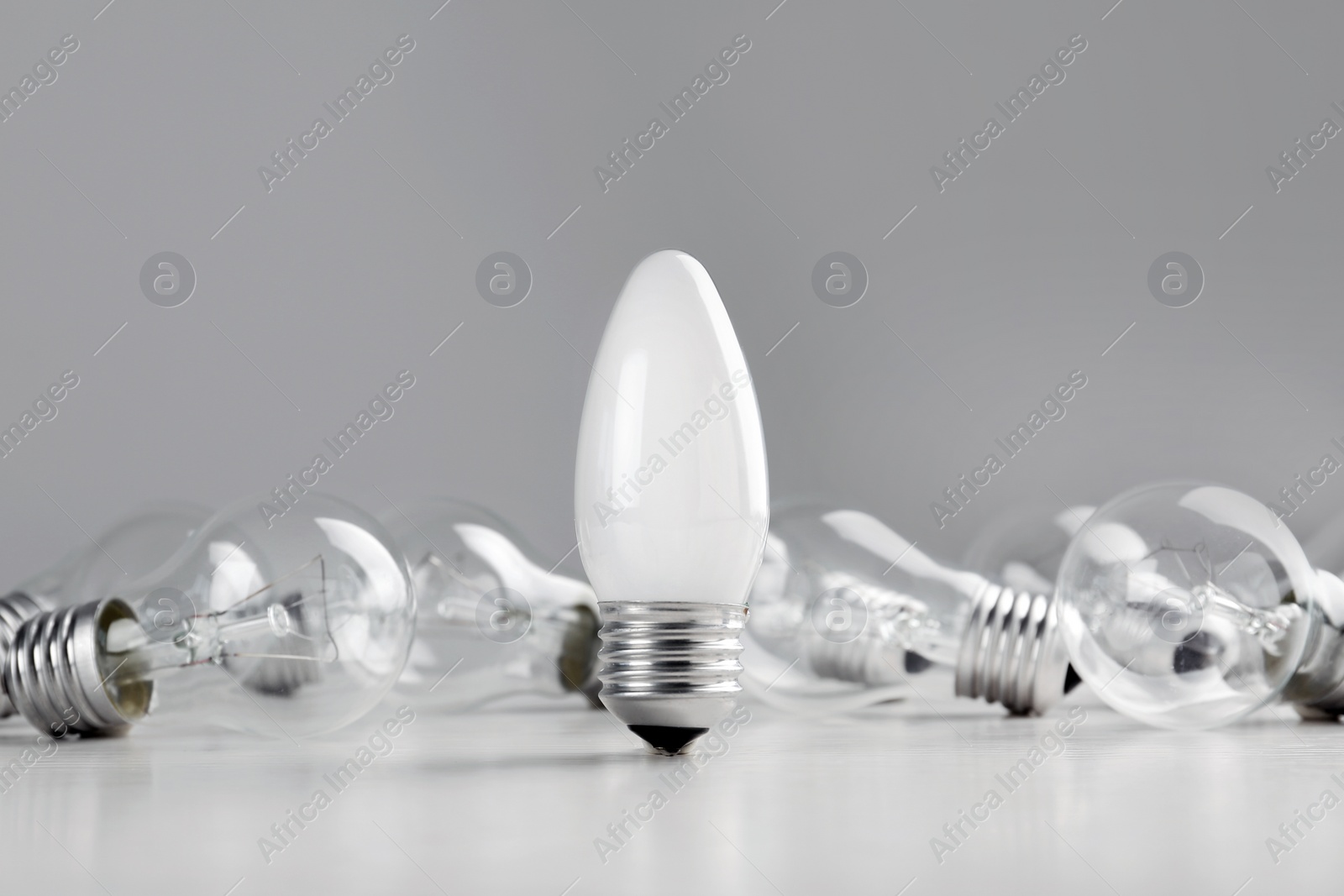 Photo of Frosted and transparent lamp bulbs on table