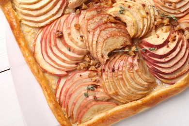 Photo of Freshly baked apple pie with nuts on white wooden table, top view