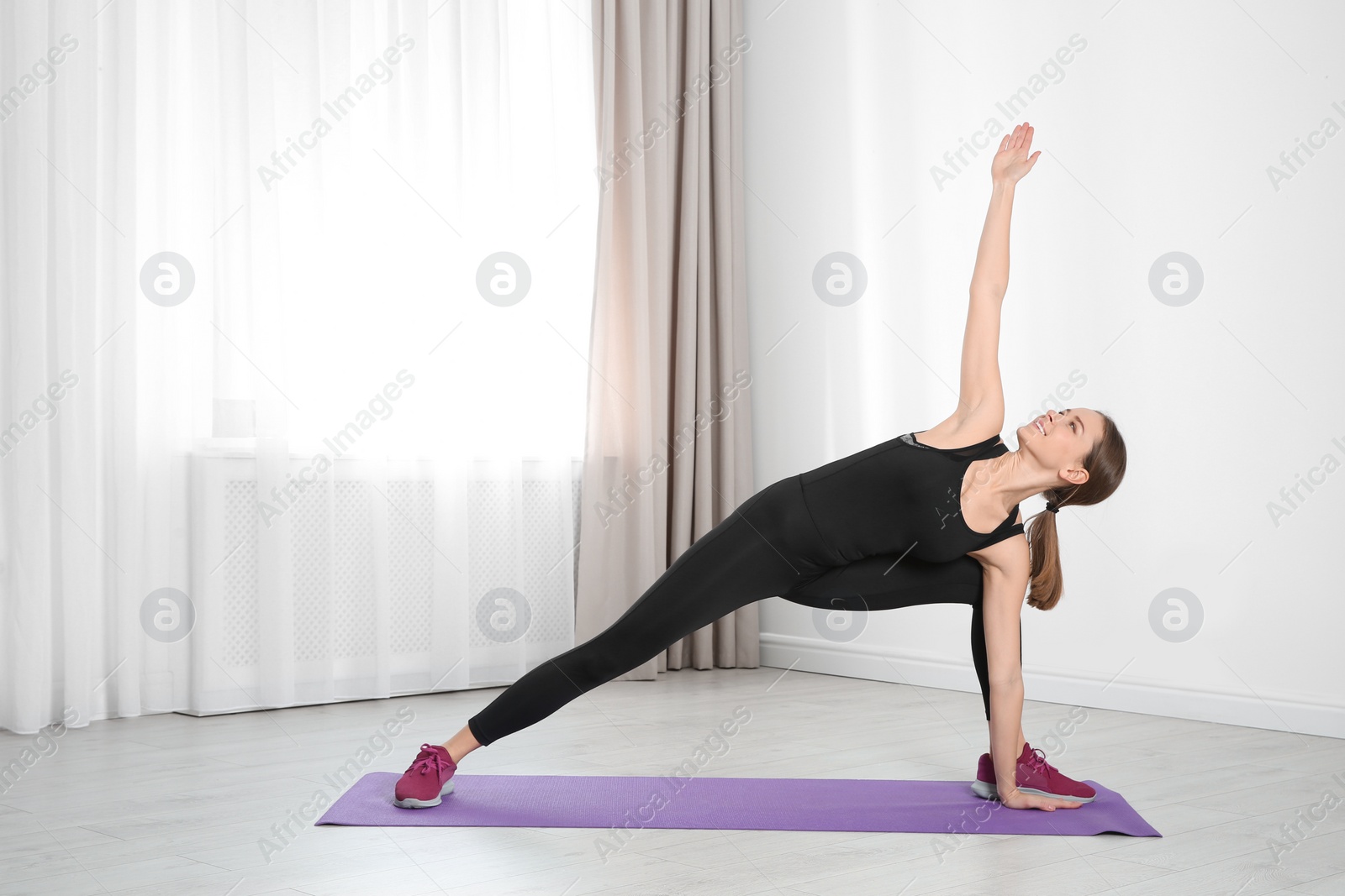 Photo of Young woman doing fitness exercises at home. Space for text