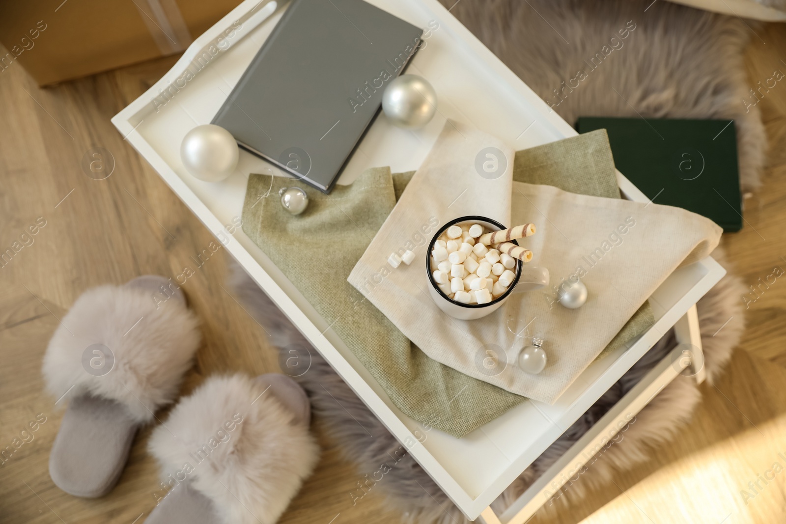 Photo of Cup of cocoa, book and balls on tray indoors, top view. Christmas celebration