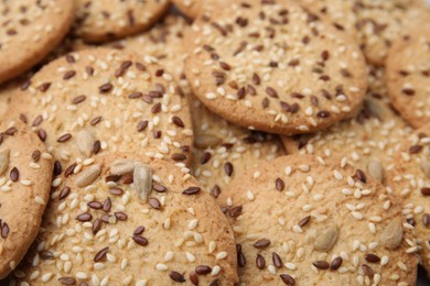 Photo of Cereal crackers with flax and sesame seeds as background, closeup