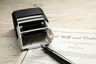 Photo of Last Will and Testament, stamp and pen on white wooden table, closeup