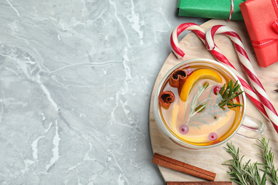 Photo of Aromatic mulled wine on grey marble table, flat lay. Space for text