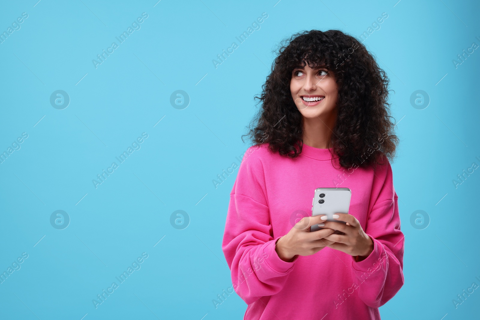 Photo of Woman sending message via smartphone on light blue background, space for text