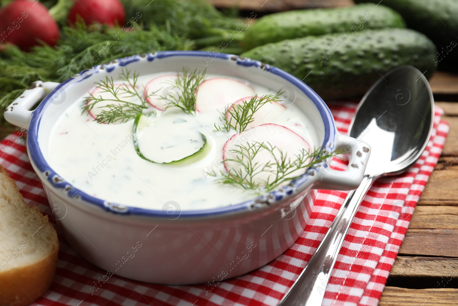 Photo of Delicious cold summer soup on wooden table, closeup