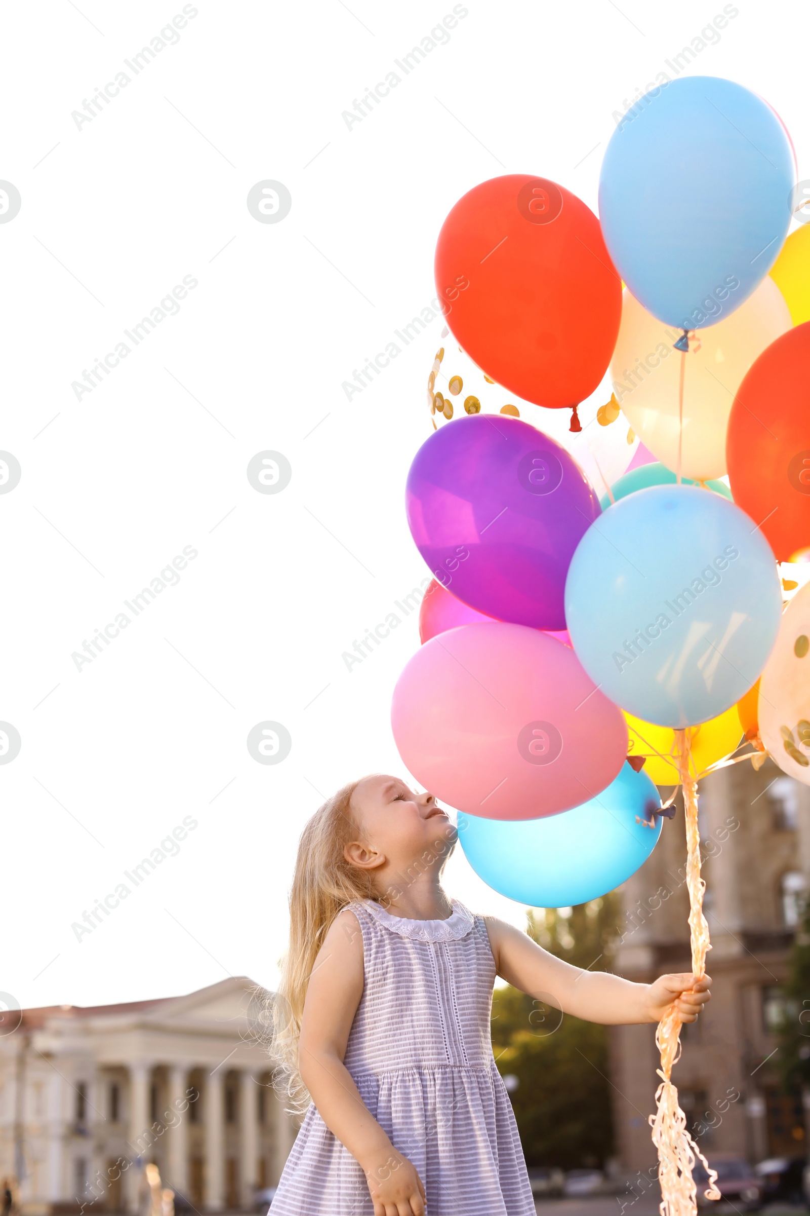 Photo of Cute little girl with colorful balloons outdoors on sunny day