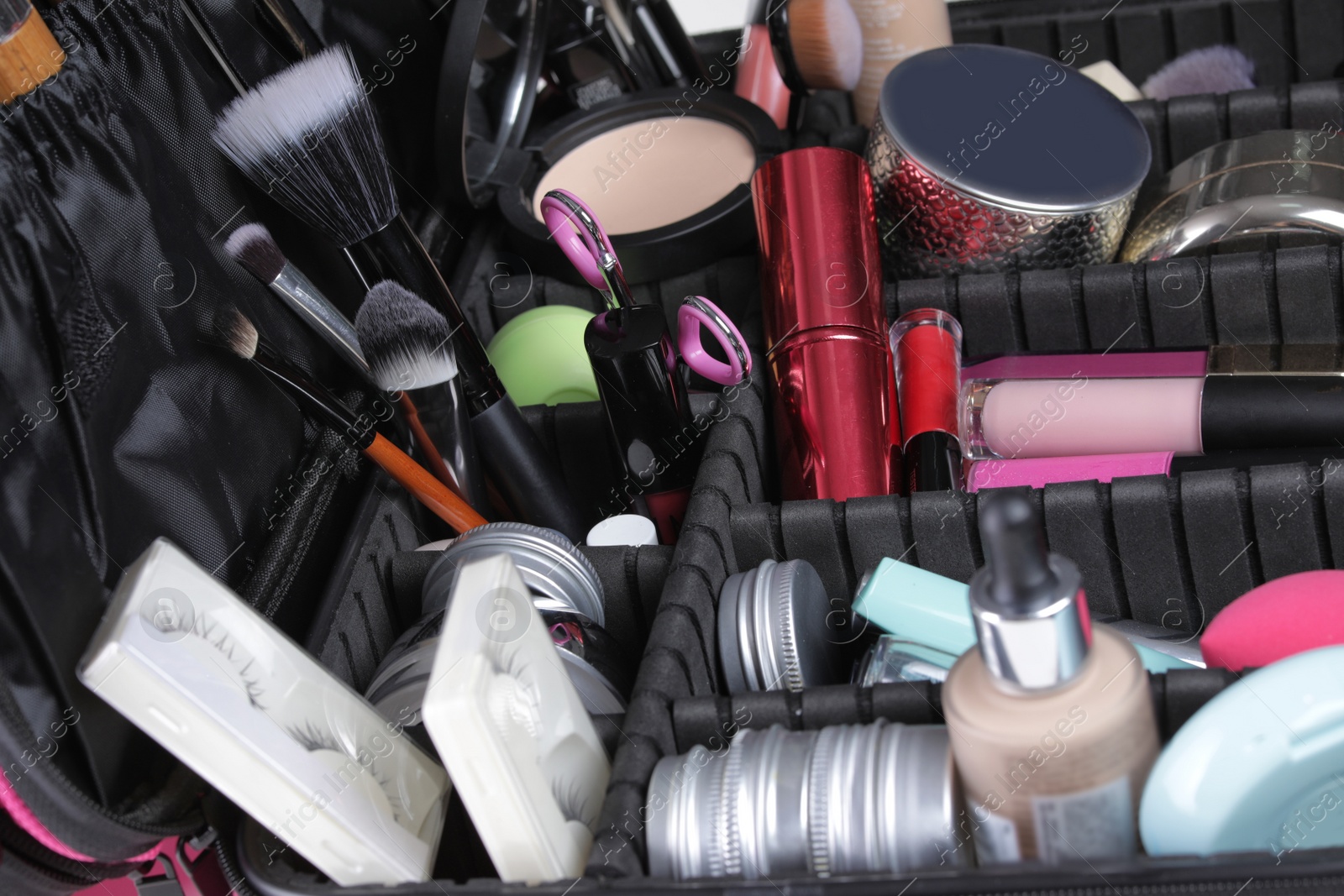 Photo of Stylish case with makeup products and beauty accessories, closeup