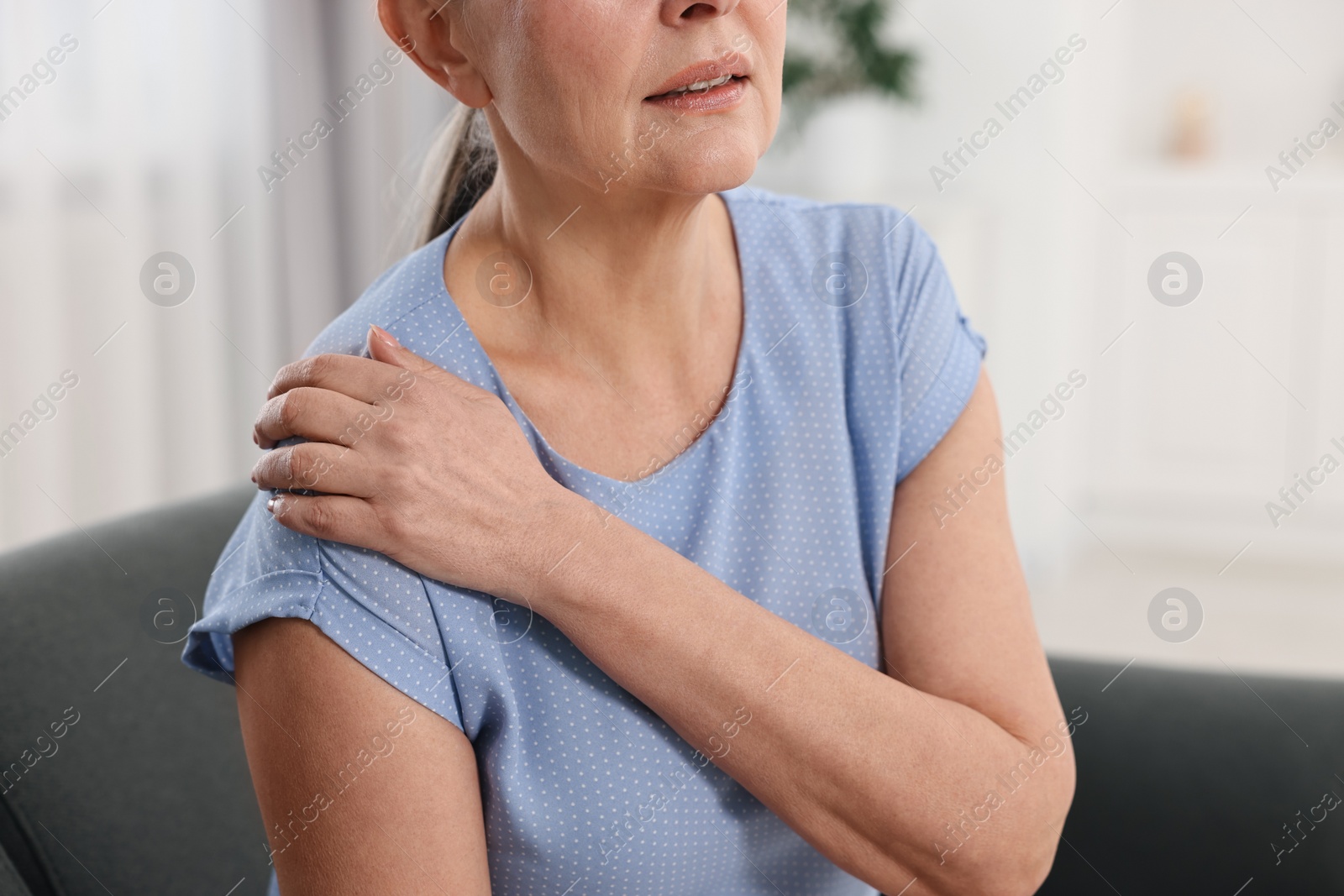 Photo of Arthritis symptoms. Woman suffering from pain in shoulder at home