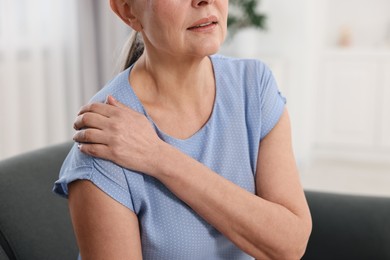 Photo of Arthritis symptoms. Woman suffering from pain in shoulder at home