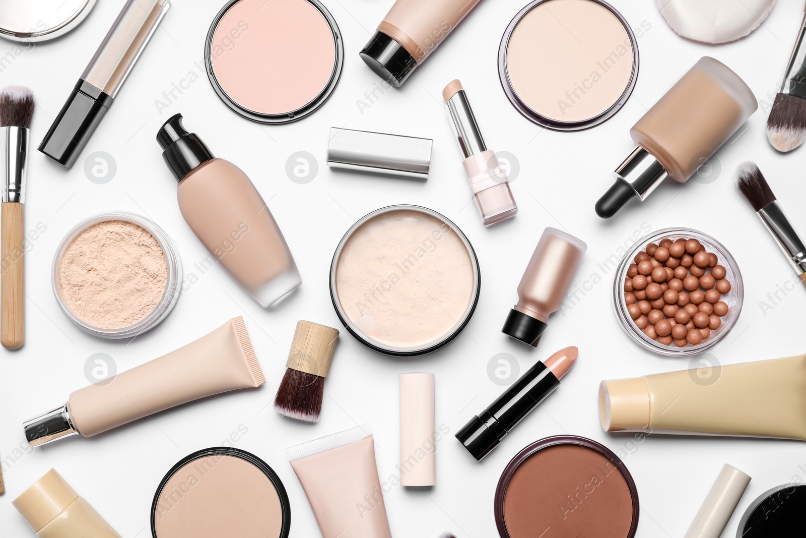 Photo of Face powders and other makeup products on white background, flat lay