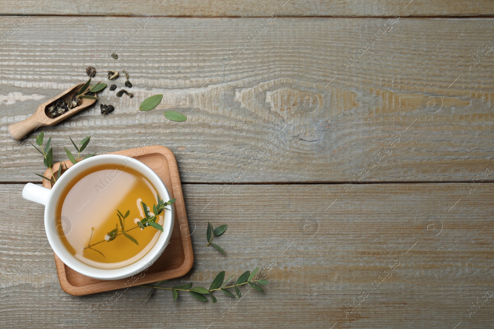 Photo of Cup of aromatic eucalyptus tea on wooden table, flat lay. Space for text